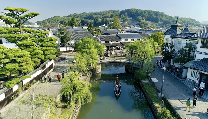 柳と白壁の町並みに沿って流れる倉敷川と川舟